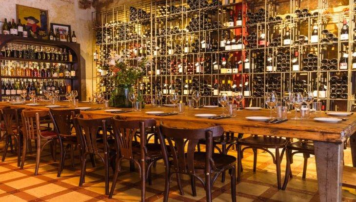 vinoteca Brutal: mesa y muro de botellas de vino